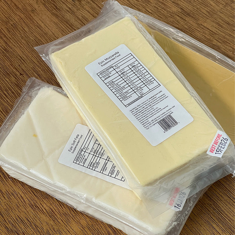 Two packages of cheese with labels on a wooden surface